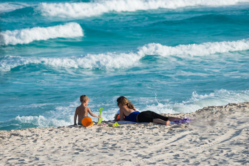 Cancun, Mexico - November 29, 2016: Mother son duo building sand castles at the beach.