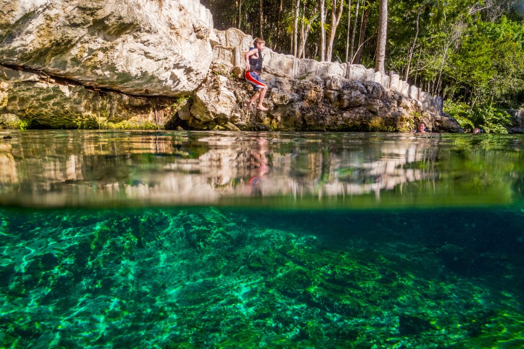 This is a boy jumping into the crystal clear waters of the Tortuga Cenote outside of Tulum, Mexico. Picture taken with a camera in a waterproof case to capture the action above and below the water.