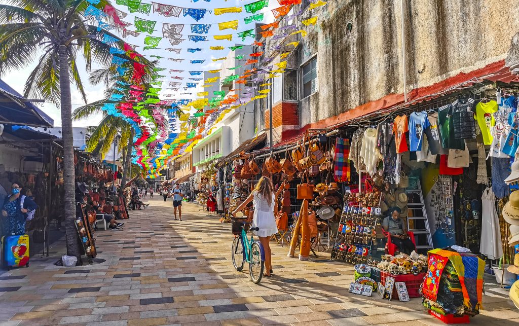 Typical street road and cityscape of La Quinta Avenida with restaurants shops stores people souvenirs and building in Playa del Carmen Playa del Carmen Quintana Roo Mexico.