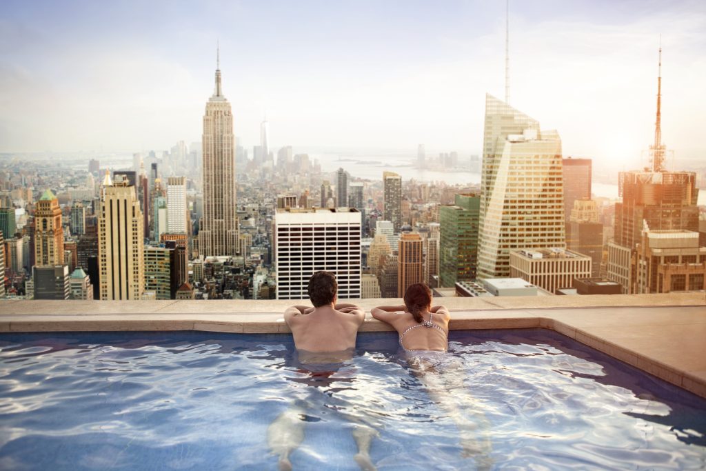 Couple relaxing in swimming pool on hotel rooftop